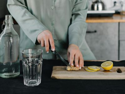 A glass of water with lemon next to a yoga mat.